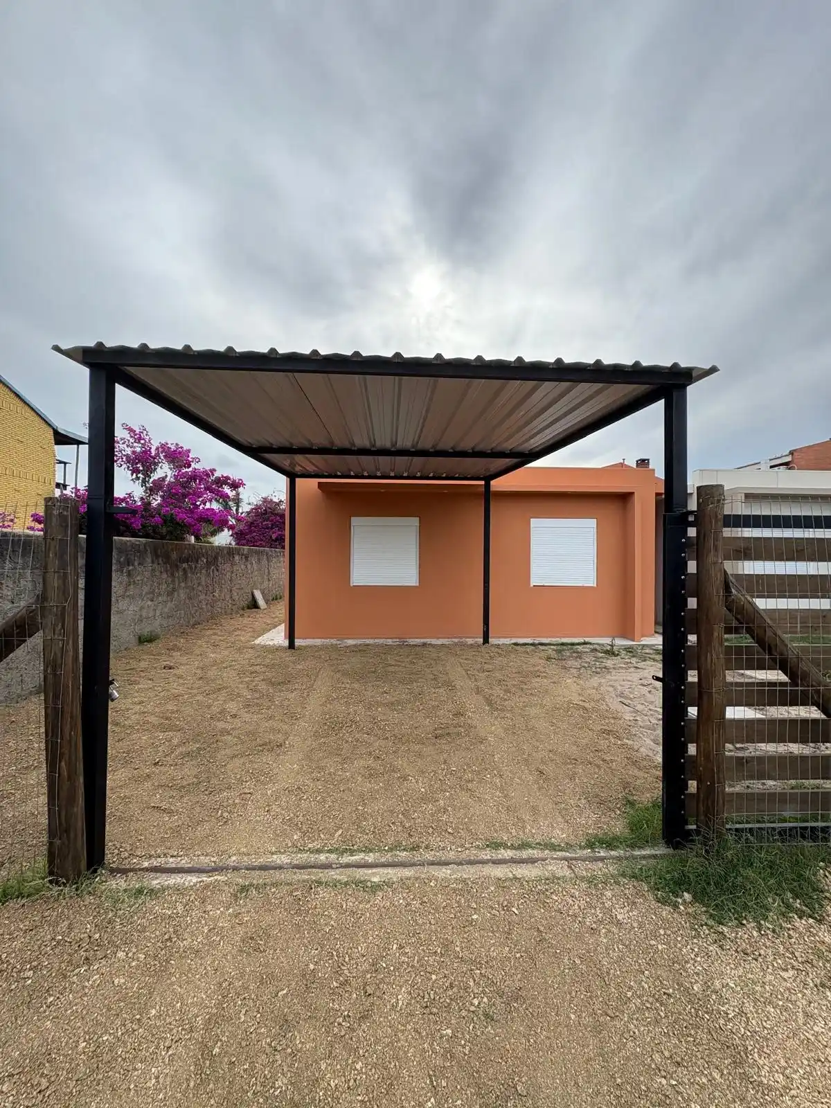 Pérgola metálica terminada en casa naranja