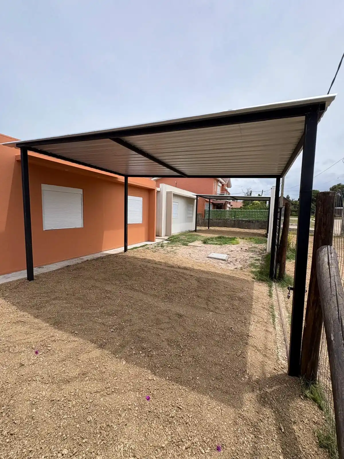 Pérgola metálica terminada en casa naranja